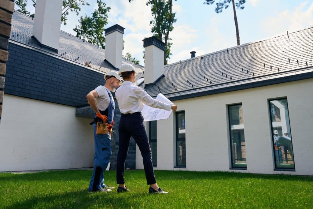 professionals inspecting the roof of a house - Turnkey Roofing Contractors