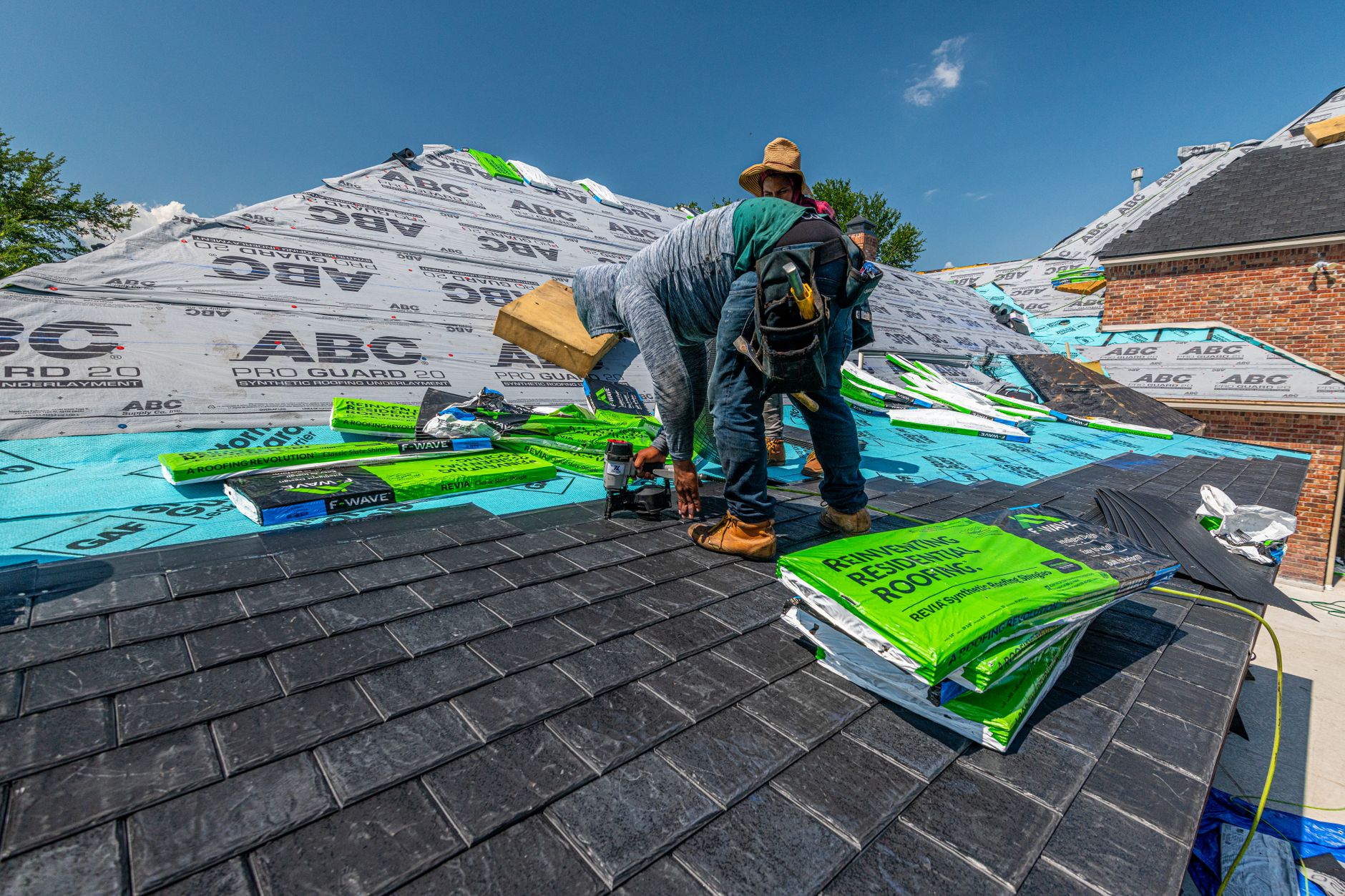 Roofer tearing off old shingles down to the decking during a roof replacement