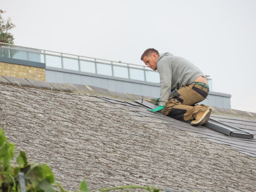 Installer applying manufacturer-matched starter strip along a roof edge